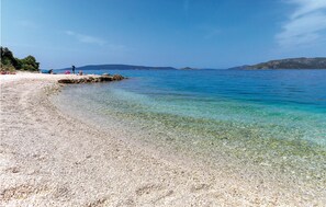 A pebble beach with clear water and distant mountains. - Amazing apartment in Okrug Donji with WiFi (Okrug Donji)