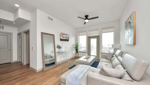 A modern living room with a sofa, a coffee table, and a ceiling fan.