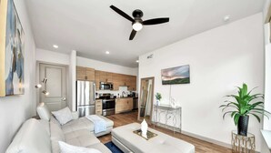 A modern living room with a sofa, coffee table, and a ceiling fan.