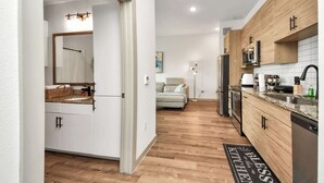 A modern kitchen with wooden cabinets, a microwave, and a refrigerator.