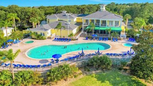 A resort with a large pool, multiple lounge areas, and a prominent building with a balcony. - Spacious 3BR Resort Condo Near Disney (Davenport)