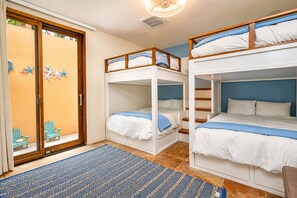 Una habitación con literas, una puerta decorada con estrellas y un tapete azul estampado.