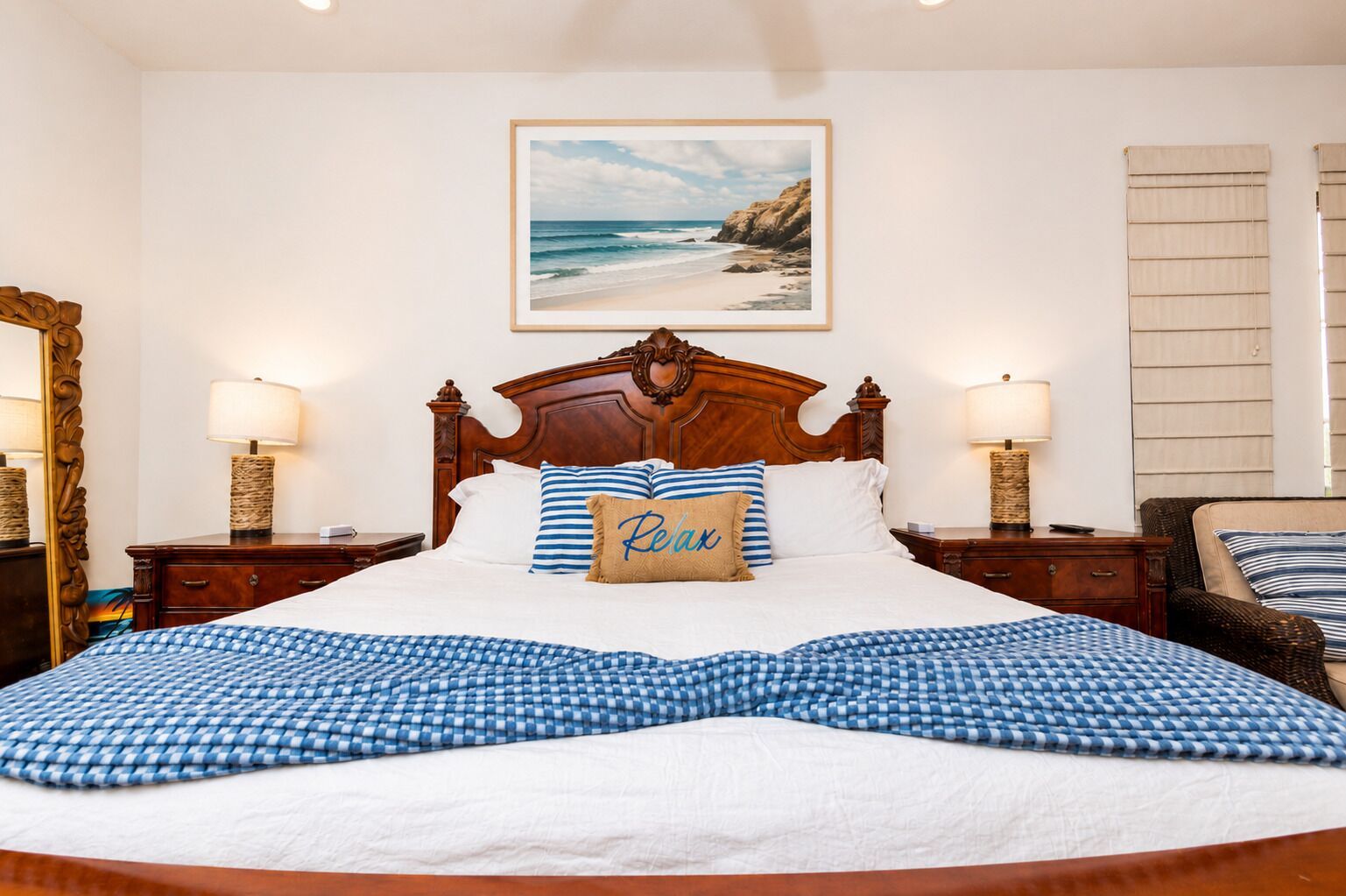 Una cama bien tendida con una colcha de cuadros, un cabecero de madera y un almohadón con la palabra 'Relax'.