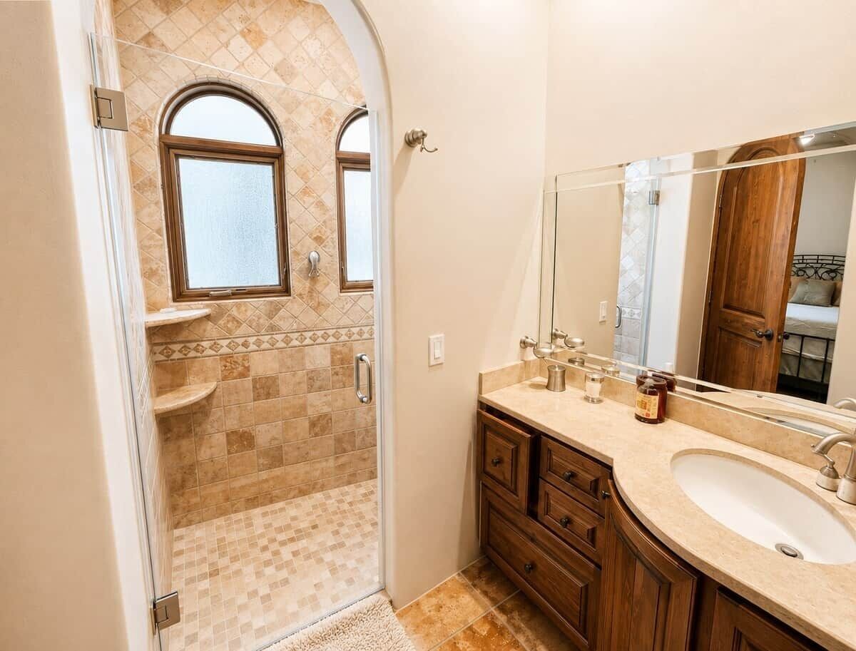 Une salle de bain avec une douche, un meuble-lavabo et un grand miroir.