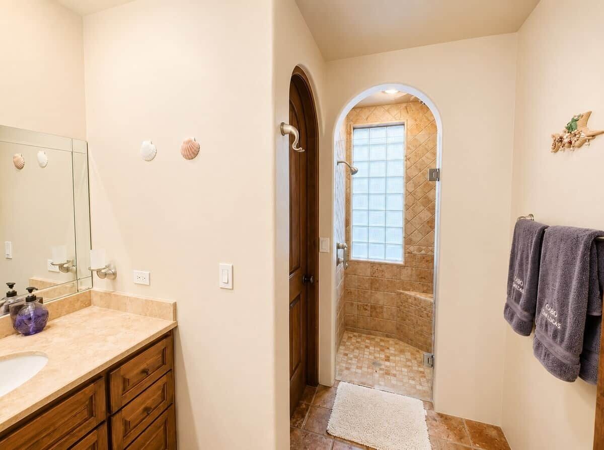 Une salle de bain équipée d’un meuble-lavabo, d’une douche et d’un porte-serviettes.