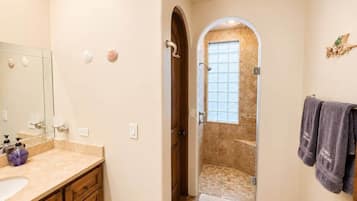 Une salle de bain équipée d’un meuble-lavabo, d’une douche et d’un porte-serviettes.
