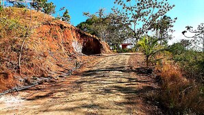 Un sendero de tierra que asciende con vegetación escasa y un cielo azul despejado.