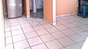 Una cocina compacta equipada con refrigerador, lavamanos y microondas.