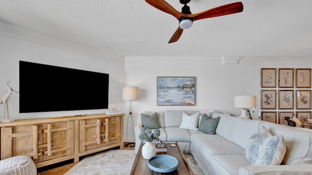 A living room with a sofa, coffee table, TV, wooden cabinet, and ceiling fan. - “Sugar Shack” 🐟 A PURE SALT PROPERTY 🐟 Brand New Rental (Orange Beach)