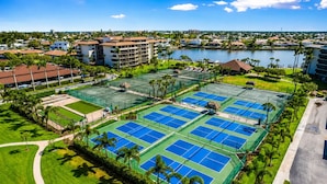 A tennis court complex with multiple courts, surrounded by greenery and buildings. - Luxury Beach Resort Marco Island Condo | Ocean Views, Pool & Beach (Marco Island)