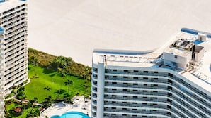 A high-rise hotel with a pool, beachfront view, and a parking area. - Luxury Beach Resort Marco Island Condo | Ocean Views, Pool & Beach (Marco Island)