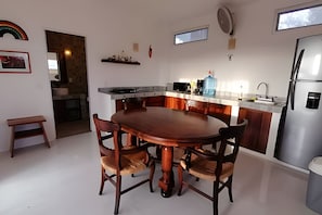A modern kitchen with a central island, a built-in oven, and a stainless steel refrigerator. - Amarilla (San Pedro Pochutla)