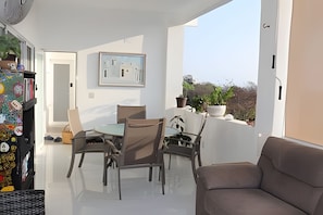 A balcony with a dining table and chairs, a sofa, and a potted plant. - Amarilla (San Pedro Pochutla)