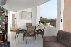 A balcony with a dining table and chairs, a sofa, and a potted plant. - Amarilla (San Pedro Pochutla)
