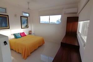 A bedroom with a bed, a ceiling fan, a window, and a door. - Amarilla (San Pedro Pochutla)