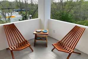 A balcony with two wooden chairs and a small table with plates. - Amarilla (San Pedro Pochutla)