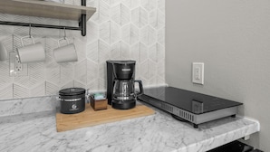 Una cocina con cafetera, olla de cocción lenta y encimera.