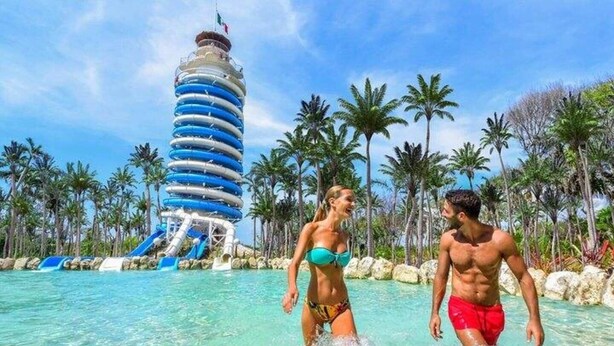 Un parc aquatique doté d’un grand toboggan et d’une haute structure cylindrique.
