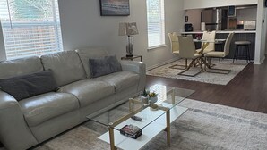 A living room with a sofa, coffee table, and a ceiling fan.