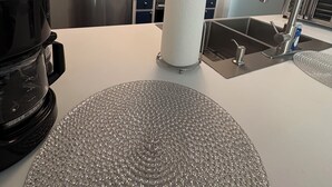 A modern kitchen with stainless steel appliances, a white countertop, and a built-in sink.