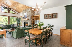 A spacious living area with a fireplace, dining table, and green upholstered furniture. - Upper Deer Valley Ski-In/Ski-Out Retreat at Silver Lake (Park City)