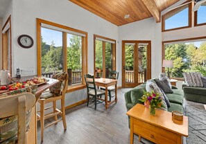 A spacious room with a dining area, a sofa, and large windows offering a view of the outdoors. - Upper Deer Valley Ski-In/Ski-Out Retreat at Silver Lake (Park City)