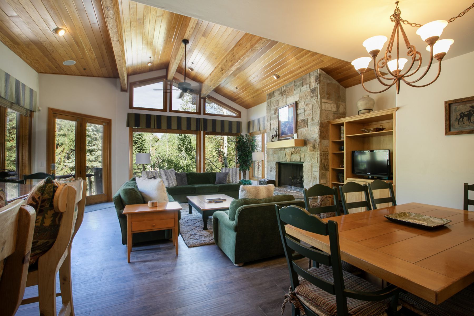 A spacious living room with a fireplace, a dining area, and a television.