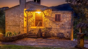 A stone building with a staircase leading to a wooden door, surrounded by grass and trees. - Wonderful private villa for 8 people with WIFI, A/C, private pool, TV and pets allowed (Roccastrada)