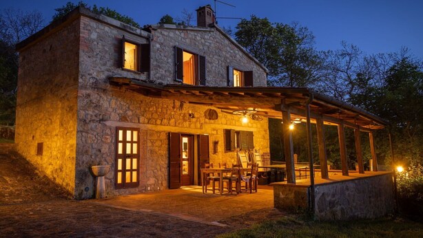 A stone house with a covered patio, wooden furniture, and a chimney. - Wonderful private villa for 8 people with WIFI, A/C, private pool, TV and pets allowed (Roccastrada)