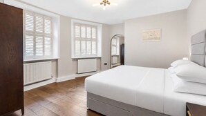 Un dormitorio con cama, armario, radiador y ventilador de techo.