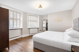 Un dormitorio con cama, armario, radiador y ventilador de techo.