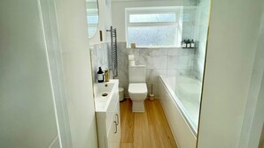 Ein modernes Badezimmer mit Toilette, Waschbecken und Badewanne.