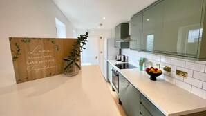 Eine moderne Küche mit einer Holzwand, einer Obstschale und einer Topfpflanze.