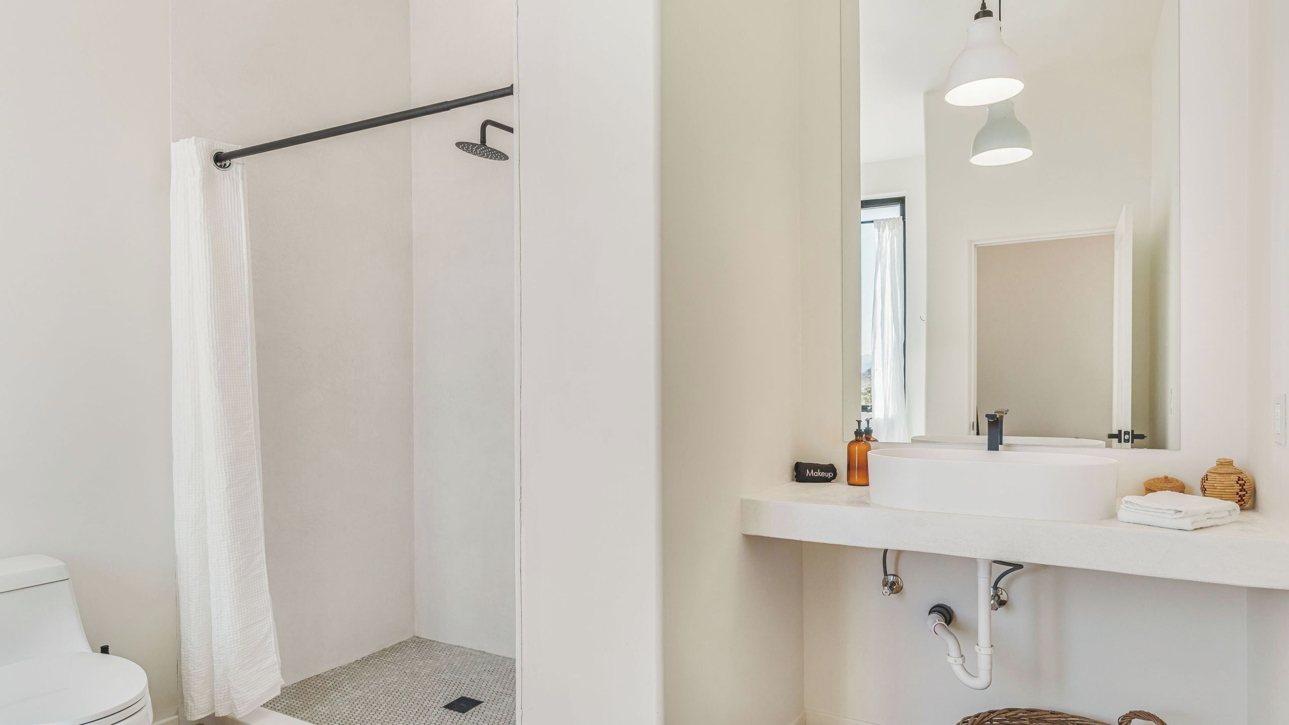 Une salle de bain moderne équipée d’une douche, de toilettes, d’un lavabo et d’un miroir.