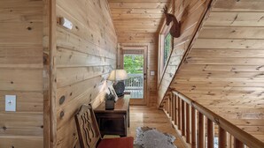 Un interno in legno con una panca, una lampada e una porta che dà sull'esterno.