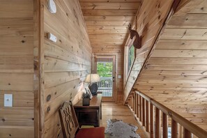 A wooden interior with a bench, a lamp, and a door leading outside. - Aska Bliss | Mountain Retreat in Aska Adventure Area (Blue Ridge)
