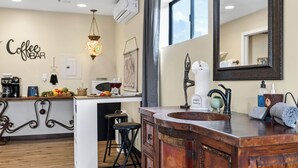 A kitchen with a coffee bar, a hanging light fixture, a sink with a towel dispenser, and a mirror. - Red Rock Duo by Avantstay - Sleeps 8, 2 Sedona Retreats With Mountain Views, Heart of West Sedona (Sedona)