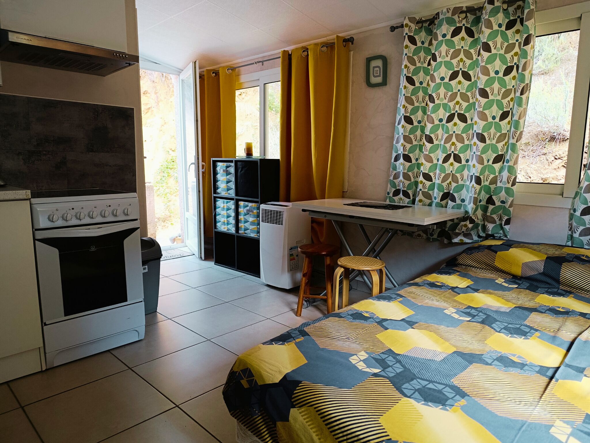 A compact kitchen with a stove, refrigerator, and a small dining area with a table and chairs.