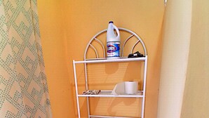 A small bathroom with a toilet, a shelf with a toilet brush, and a roll of toilet paper. - New room aere and casita wifi pedasi/venao panama (El Ciruelo)