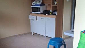 A room with a kitchenette, a blue stool, and a green bag on a wall. - New room aere and casita wifi pedasi/venao panama (El Ciruelo)
