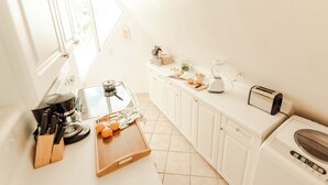 Eine Küche mit Herd, Mixer, Toaster und Waschmaschine.
