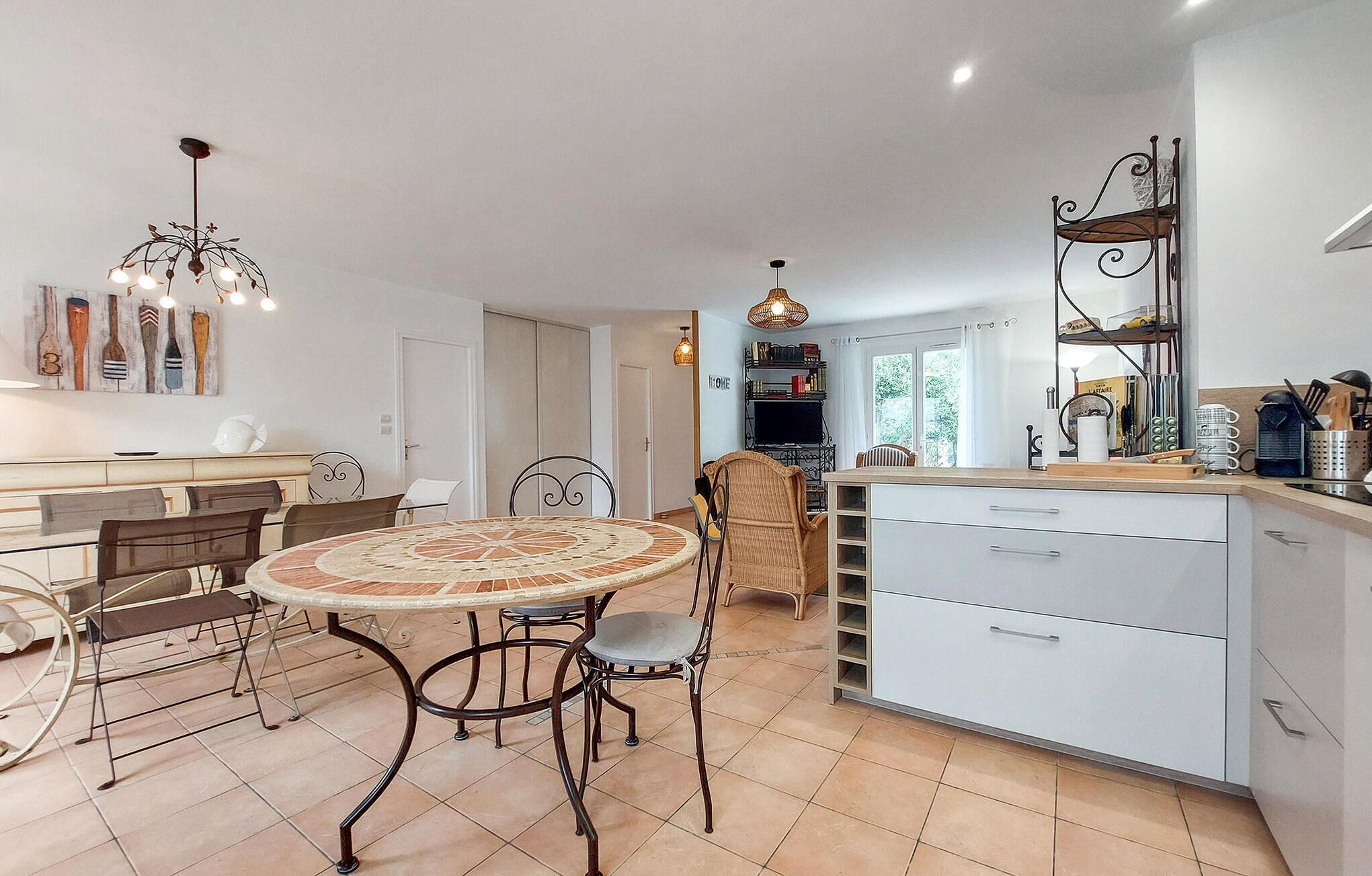 Een moderne keuken met een ronde eettafel, stoelen en een witte kast.