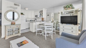 Een knus woongedeelte met een kitchenette, een eethoek, een televisie en een zithoek.