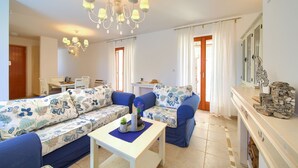 Ein Wohnzimmer mit einer Couch, einem kleinen Tisch, einer Deckenleuchte und einem Kamin.