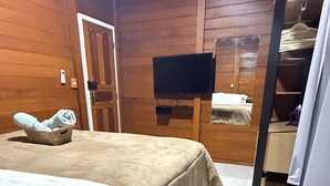 Una habitación acogedora con una cama, un televisor y un armario de madera.