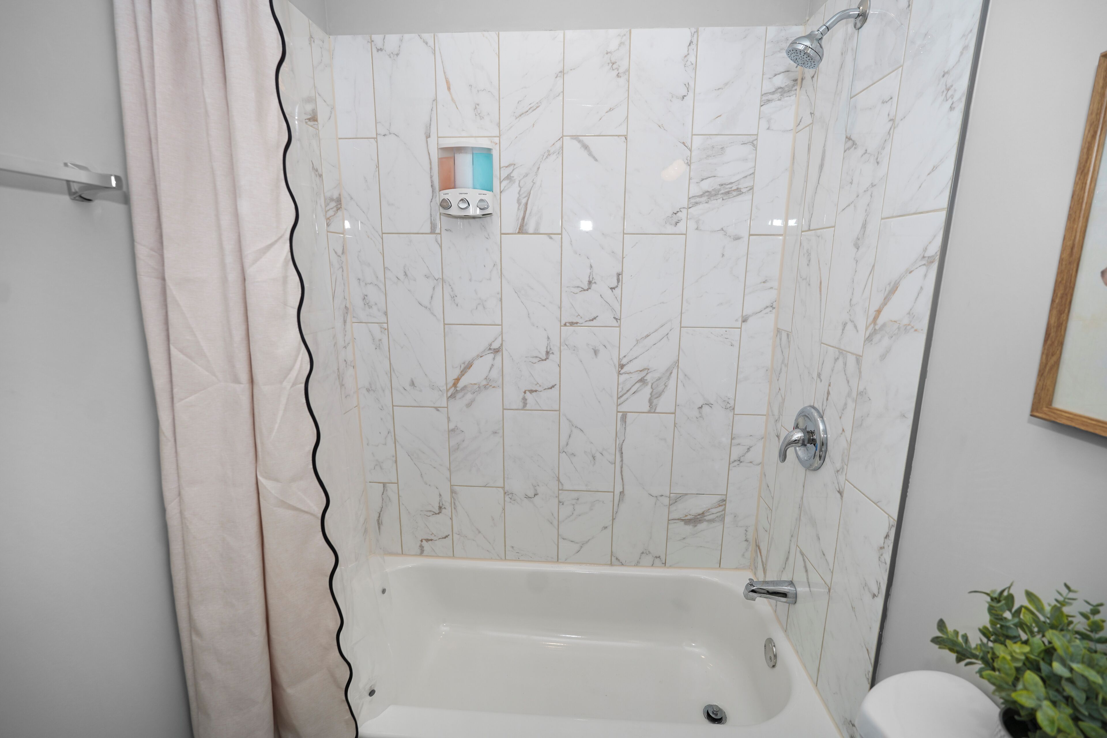 Un bagno con una vasca, una doccetta e un pannello di controllo.