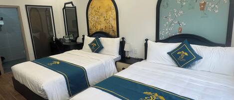 A hotel room with two beds, a large mirror, a wall clock, and a decorative wall piece.