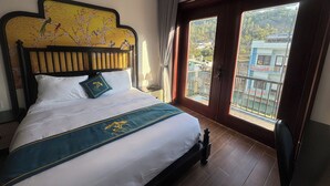 Habitación de hotel con cama, vistas al exterior y un balcón.