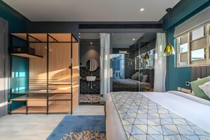 A modern bedroom with a bed, a walk-in closet, a bathroom, and a view of the outside. - Hotel BL (Hyderabad)