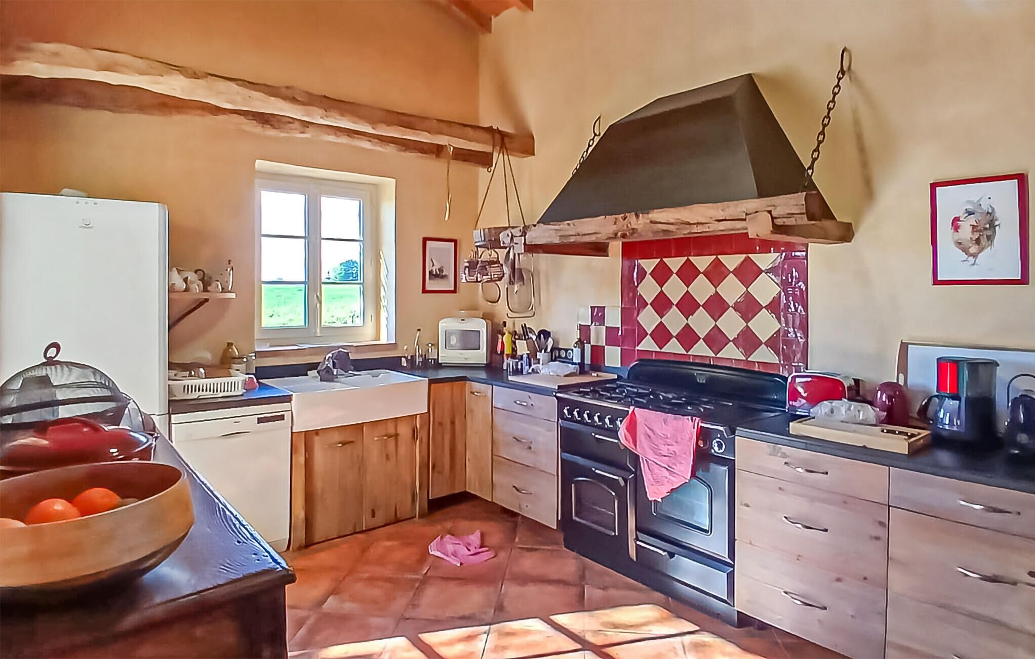 Une cuisine avec des meubles de rangement en bois, une cuisinière, un évier et une fenêtre.